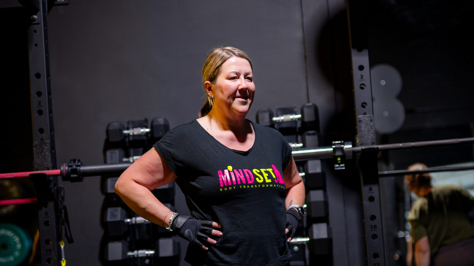 A Mindset member in her 50s standing confidently by the squat rack in the studio in Southampton
